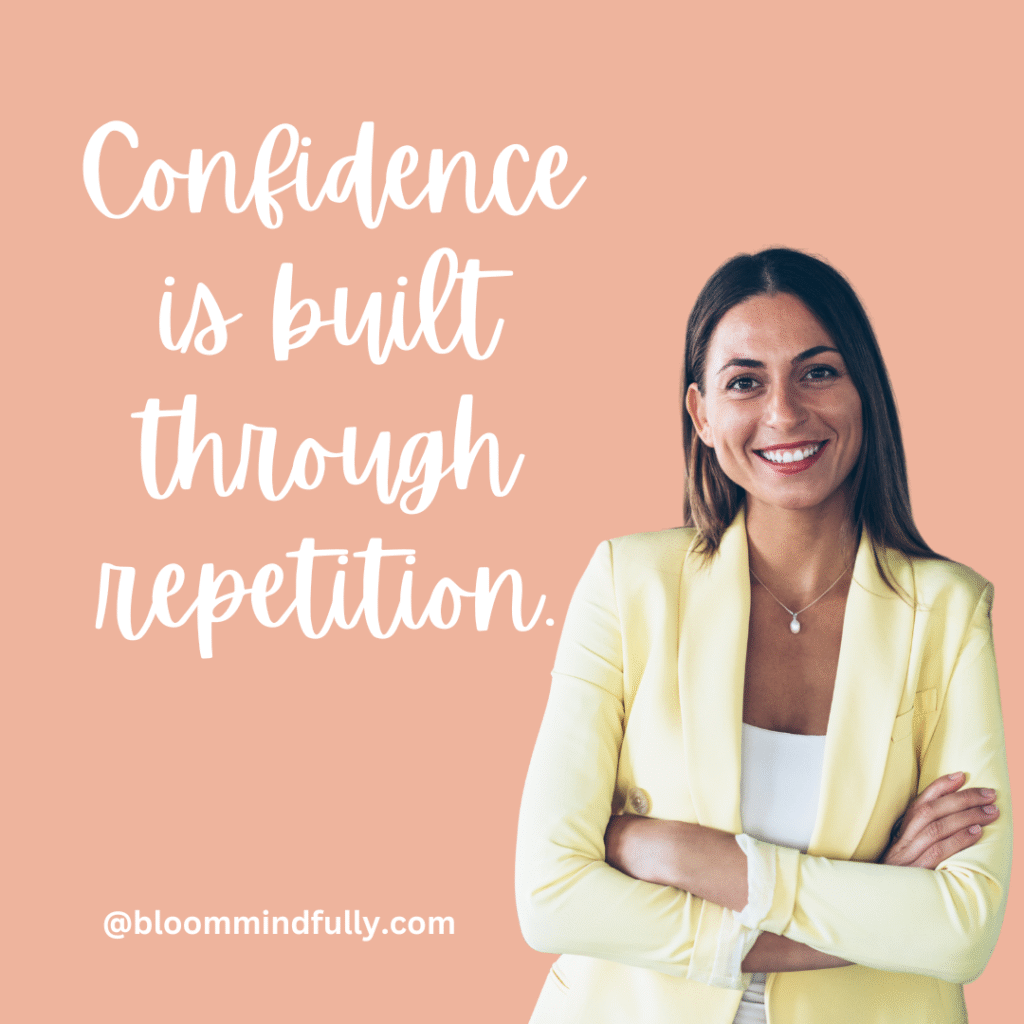 Smiling woman in a yellow blazer stands confidently beside the quote “Confidence is built through repetition,” inspiring mom entrepreneurs to build confidence through daily action.