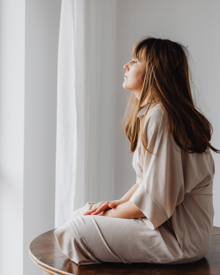 Woman sitting quietly in a reflective moment, representing feeling off without knowing why