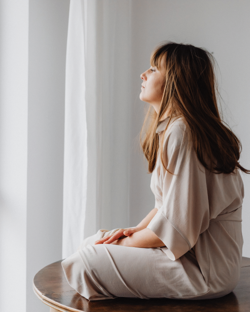 Woman sitting quietly in a reflective moment, representing feeling off without knowing why